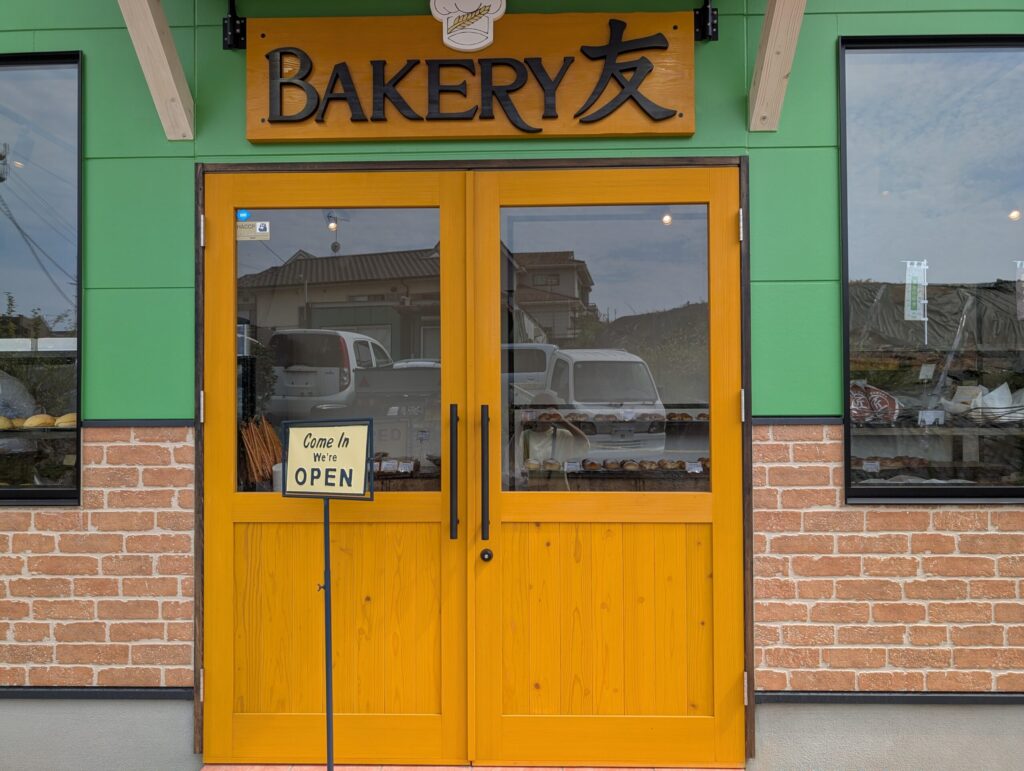 BAKERY友の入口ドア。看板に店名のロゴが掲げられている