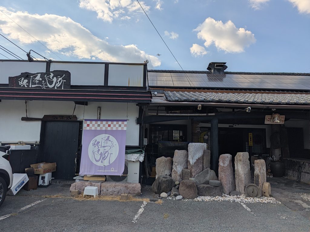 熊本市東区下南部の居酒屋「魚屋さんの台所」の外観と紫の暖簾