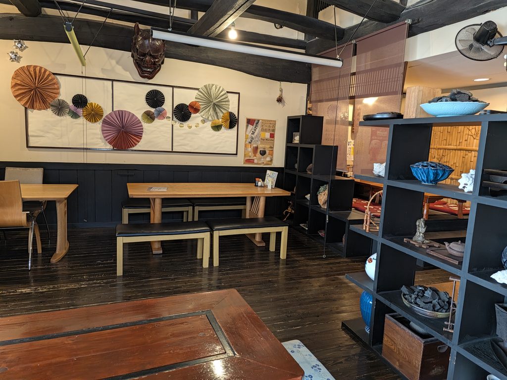魚屋さんの台所の店内に飾られた和箪笥と面などの和風の調度品